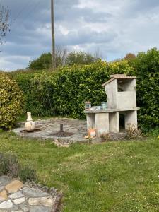 a stone oven in the middle of a yard at Maison 6 personnes La Tourelle in Saulchoy