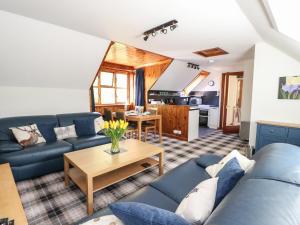 a living room with a blue couch and a table at Upper Brackendale in Taynuilt