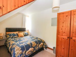 een slaapkamer met een bed en een houten kast bij Upper Brackendale in Taynuilt
