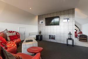 ein Wohnzimmer mit einem Sofa und einem TV an der Wand in der Unterkunft Valleyview House in Thurso