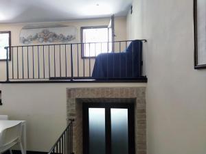 a living room with a fireplace and a stair case at Grillotti Apartment in Todi