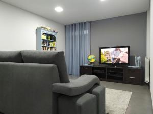 ein Wohnzimmer mit einem Sofa und einem TV in der Unterkunft Casa da Nanda in Crespos