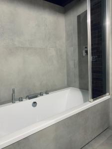a white bath tub in a bathroom with a window at Loft De Girarda in Żyrardów