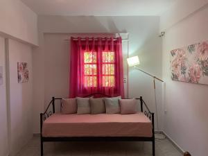a bed in a room with a red window at "Kouremenos Beach" seaside Apartments in Palekastron +30 photos