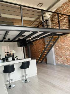 a loft with a staircase in a room with stools at Loft De Girarda in Żyrardów