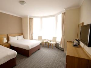 ブラックプールにあるAshley Victoriaのベッド2台、薄型テレビが備わるホテルルームです。