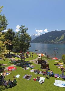 eine Gruppe von Menschen, die auf dem Rasen eines Parks sitzen in der Unterkunft Apartments Lakeside 29 Zell am See in Zell am See