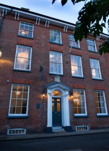 a red brick building with a door and windows at East Walls Hotel in Chichester