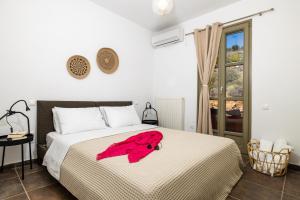 a bedroom with a large bed with a red towel on it at Front Row Seat to the Aegean by Neuvel in Ioulis