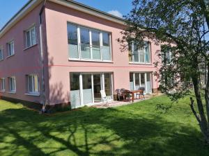 una casa rosa con césped delante en 85 qm Wohnung Pauluste mit Terasse und Garten en Rostock