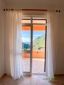 a door is open to a room with a view of the ocean at Gardens Guest House in São Vicente