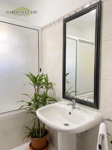 a bathroom with a sink, toilet and tub at Gardens Guest House in São Vicente