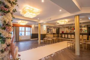 a lobby with tables and chairs and a bar at Enterkine Country House Resort in Annbank