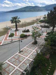 an empty street next to a beach with palm trees at Melachrini Apartments in Nea Vrasna