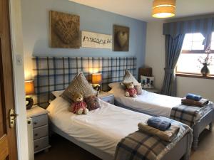 a bed room with two beds and two lamps at Valleyview House in Thurso