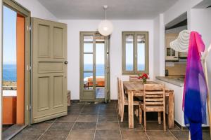 uma cozinha e sala de jantar com mesa e cadeiras em Front Row Seat to the Aegean by Neuvel em Ioulida