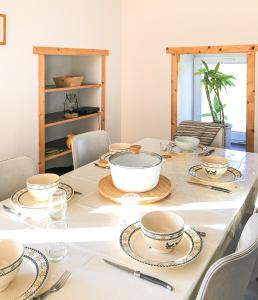 a dining room table with bowls and plates on it at Gites des Casernes in Saint-Christophe