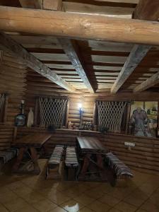 a room with a table and benches in a cabin at Садиба у Попа in Lumshory