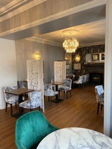 a dining room with tables and chairs and a chandelier at Dunedin Country House in Patrington