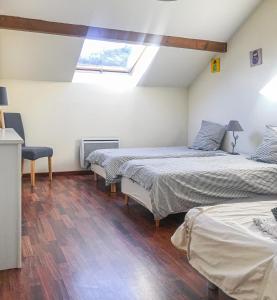 a bedroom with two beds and a skylight at Gites des Casernes in Saint-Christophe
