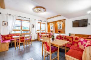 a restaurant with red chairs and a table and a couch at Pension Abendruh in Kaprun