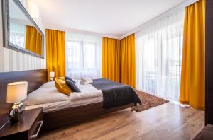 um quarto com uma cama grande e cortinas amarelas em Delfin em Międzywodzie
