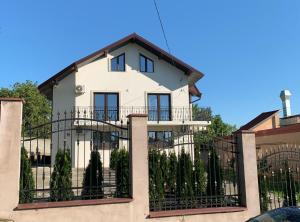 uma casa branca com uma cerca preta em Apartament Micsunelelor em Iaşi
