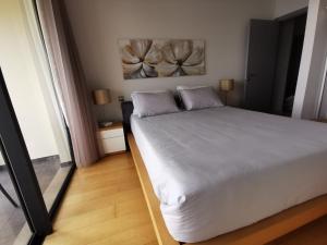 een slaapkamer met een wit bed en een spiegel bij Sun Island Apartments in Funchal