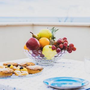 a bowl of fruit and a bowl of pastries on a table at Il carrubo B&b in Maratea +71 photos