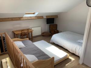 - une chambre avec 2 lits, un bureau et une table dans l'établissement Studio proche Orleans centre, à Saint-Jean-le-Blanc