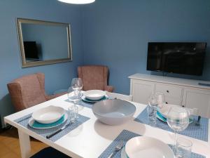 a dining room table with plates and glasses and a television at P in centro in Sestri Levante