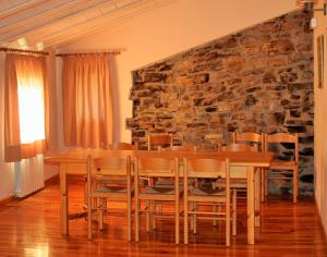 Rectoria de Claverol في Claverol: غرفة طعام مع طاولة وجدار حجري