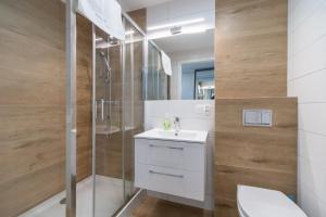 a bathroom with a shower and a sink and a toilet at Apartamenty Proeko Polonia in Kołobrzeg