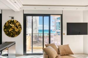 ein Wohnzimmer mit einem Sofa und einem großen Fenster in der Unterkunft Somptueux logement,Cannes Croisette,4 Étoiles**** in Cannes