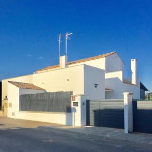 un edificio blanco con puerta y garaje en El Venero, en San Nicolás del Puerto