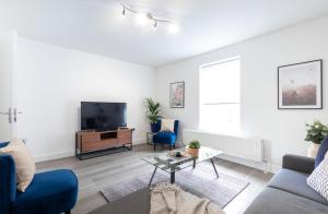 a living room with a couch and a tv at The White House By Select SA in Reading
