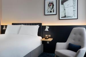 a hotel room with a white bed and white walls at Leonardo Hotel Bristol City in Bristol