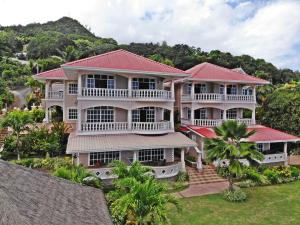 une vue aérienne sur une grande maison avec des toits rouges dans l'établissement Au Fond De Mer View, à Anse Royale