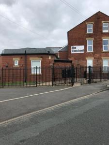 a black fence in front of a brick building at spacious apartment close to city centre with free secure parking in Leeds