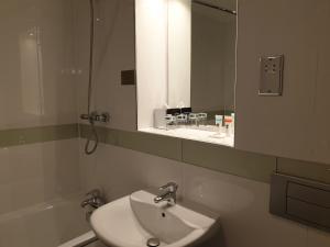 a bathroom with a sink and a mirror at Legacy Preston International Hotel in Preston