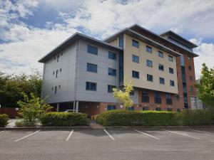 a large white building with a parking lot at Legacy Preston International Hotel in Preston