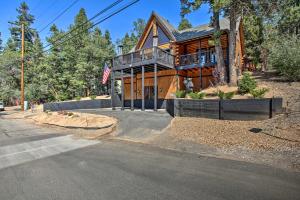 a large wooden house with a balcony on a street at Spacious Big Bear Lake Cabin with Deck Less Than 1 Mi to Ski in Big Bear Lake