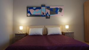 a bedroom with a large bed with two lamps on it at Apartments Tatjana in Jagodina
