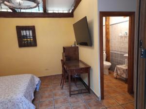 een slaapkamer met een bed, een bureau en een televisie bij Casa Blanca in Alhama de Aragón