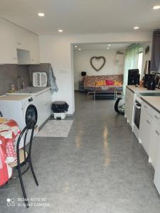 eine Küche und ein Wohnzimmer mit einem Sofa in der Unterkunft GLAM in Saint-Jean-dʼArvey