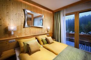 um quarto com uma cama, um espelho e uma janela em Chalety Horská Lúka Jasná em Demanovska Dolina