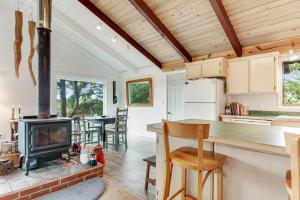a kitchen and living room with a fireplace and a stove at Dune Grass Cottage in Copalis Beach