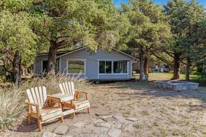 two chairs sitting in front of a house at Dune Grass Cottage in Copalis Beach