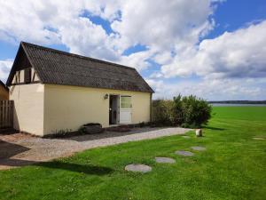 a small house with a green field behind it at Feriehus Nord på Rødkærgård in Kerteminde