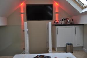a room with a tv on a wall with red lights at The Westbourne in Bowness-on-Windermere
